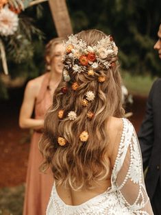 the back of a woman's head with flowers in her hair and two other people behind her