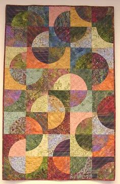 a quilt hanging on the wall with many different colored circles in it's center