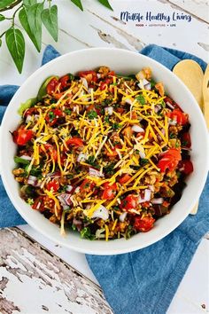 a white bowl filled with taco salad on top of a blue towel