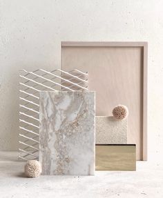 three different types of marble on display in front of a white wall with gold accents