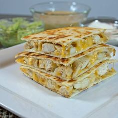 three quesadillas stacked on top of each other on a square white plate