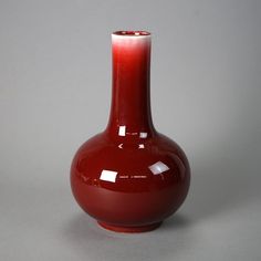 a red vase sitting on top of a table