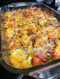 a casserole dish with tomatoes, cheese and other toppings