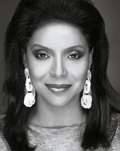 a black and white photo of a woman wearing earrings