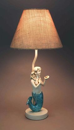 a lamp with a mermaid sitting on top of it