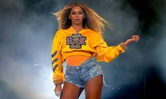 a woman in yellow shirt and jean shorts on stage with words above her that read, beyond is donaing $ 100k to 4 hbcus