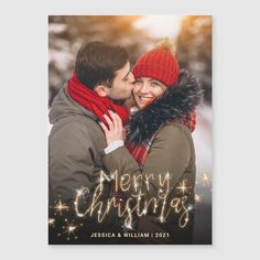 a man and woman in winter clothes hugging each other with the words merry christmas written on it