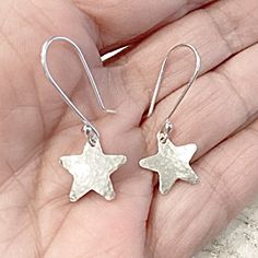 These Silver Star Earrings are a perfect gift for any stargazer, astrology buff or a lovely Christmas accessory. Timeless and ageless these will never go out of style.  The stars are cut from sterling silver sheet and dangle from MetalRocks signature handmade Ear Wires. My ear wires are a little longer than the average at .75 inches.  Should you prefer a smaller ear wire please just let me know.  The stars are a half inch in height and width.  The earrings will come in a lovely black gift box with rubber earrings backs for safety.  I've been studying astrology since the 1970's and have several published columns. Should you wish an astrology chart run please contact.  All my pieces are handmade by me personally especially for you! Adjustable Star Charm Earrings For Gift, Handmade Star-shaped Earrings For Gift, Celestial Star-shaped Hypoallergenic Earrings, Handmade Dainty Star Earrings, Celestial Star Hypoallergenic Earrings, Celestial Earrings With Star Charm As Gift, Silver Star Print Jewelry As Gift, Silver Jewelry With Star Print As Gift, Silver Star Print Jewelry For Gift