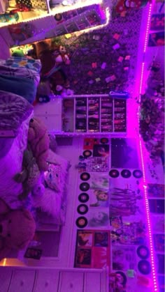 a room filled with lots of stuffed animals and purple lights on the wall above it