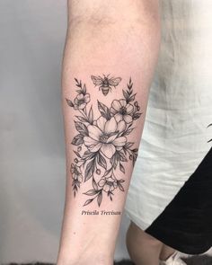 a black and white photo of a woman's leg with a flower tattoo on it