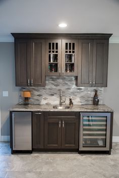 a kitchen with gray cabinets and marble counter tops