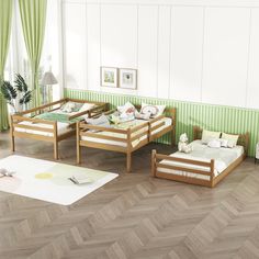 three wooden beds sitting on top of a hard wood floor next to a green wall