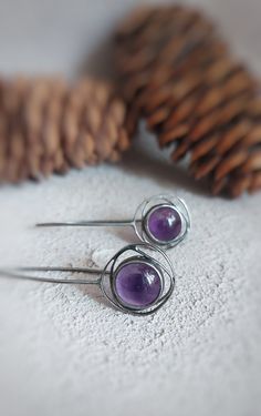 This oxidized sterling  silver purple earrings are handmade and unique. Because of this, there may be small difference in each piece. I used sterling silver (925) and amethyst gemstone  with silver smithing technique.  Since amethyst is a natural stone, there may be slightly difference in shades of purple. This lovely earrings are very suitable for daily use. Amethyst is the birthstone of february and Aquarius. You can choose it's a gift alternative for geometric jewelry and purple  lovers. Dime Gemstone Metal Earrings As Gift, Purple Round Metal Earrings, Artisan Purple Earrings With Ear Wire, Purple Artisan Earrings With Ear Wire, Unique Handmade Amethyst Earrings, Purple Metal Earrings As Gift, Purple Metal Earrings For Gift, Round Earrings With Oxidized Finish As Gift, Round Oxidized Finish Earrings As Gift