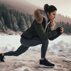 a woman squatting in the snow with her legs crossed and wearing black running shoes