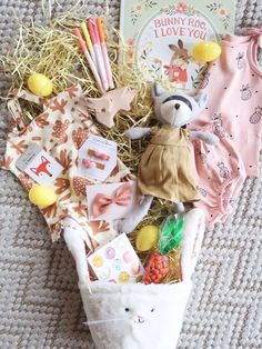 an assortment of baby items laid out on the floor next to a card and book