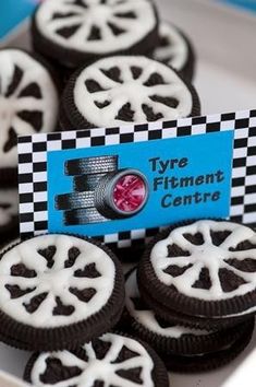 there are some cookies with black and white icing on the top one has a name tag that says tyr's fitmcent centre