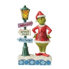 the grinch is standing next to a lamp post