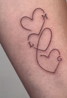 a tattoo on the leg of a woman with two hearts and an arrow in the shape of a heart