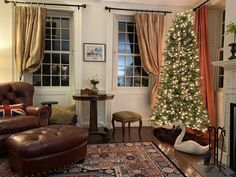 a living room filled with furniture and a christmas tree in front of a fire place