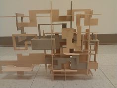 a sculpture made out of wooden blocks and shelves on top of each other in a room