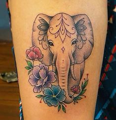 an elephant with flowers on it's leg