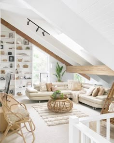 a living room filled with furniture and lots of white bookshelves on the wall