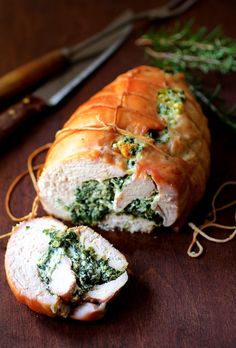 a loaf of bread with spinach and cheese on it next to a pair of scissors