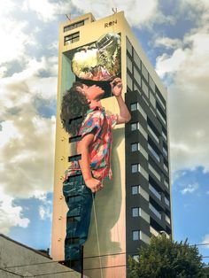 a man standing on top of a tall building next to a giant billboard with a woman blowing bubbles