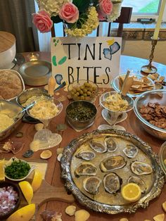 a table filled with lots of different types of food on top of a wooden table