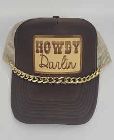 Add some southern charm to your wardrobe with this "Howdy Darlin'" trucker hat! This western-inspired hat features a vintage-style patch with bold "Howdy" text and a playful "Darlin'" script below. The rich brown front panel and contrasting tan mesh back give it a rustic yet modern look, perfect for a casual day out or your next rodeo adventure. Whether you're looking to spice up your own style or searching for a unique gift, this hat has country flair and personality. Key Features: *Western-Inspired Patch: "Howdy Darlin'" patch adds a touch of country sass and fun. *Classic Trucker Design: Mesh back offers breathability, and the adjustable snapback ensures a comfortable fit. *Stylish Color Combination: Rich brown front with a tan mesh back gives a versatile, down-to-earth appeal. *Perfect Country Hats, Country Fair, Cute Hat, Hat Custom, Down To Earth, Southern Charm, Cute Hats, Color Combination, Spice Up