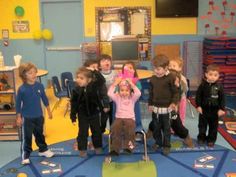 a group of children standing on top of a trampoline in a school gym