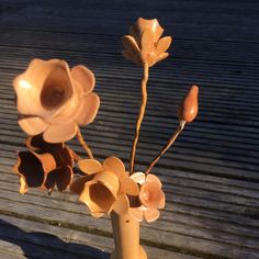 a vase filled with flowers sitting on top of a wooden table