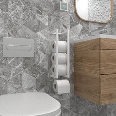 a bathroom with a toilet, paper roll holder and wooden cabinet next to the sink