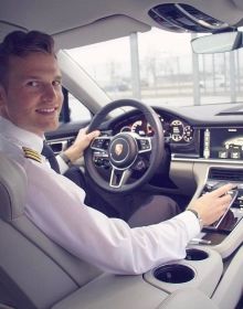 a man sitting in the driver's seat of a car with steering wheel and dashboard