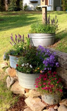 three flower pots sitting on the side of a wooden fence