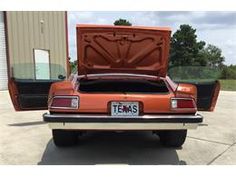 an orange car with its hood open