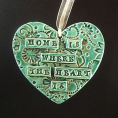 a heart shaped ornament with the words home is where the heart is