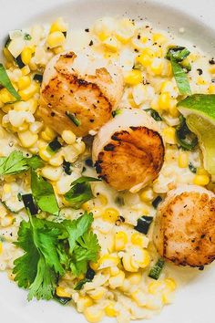 scallops and corn in a white bowl with garnish