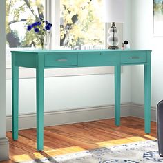 a blue table with two drawers in front of a window