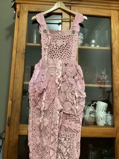 a pink dress hanging on a wooden hanger