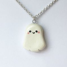 a white necklace with a ghost face on it