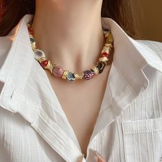 Introducing the Valerie Ceramic Beaded Necklace, a statement piece that combines elegance with artistic flair. This necklace features a beautiful array of ceramic beads, each uniquely hand-painted in vibrant colors and wrapped with gold-toned elements, adding an exquisite touch to any outfit. The sturdy craftsmanship and eye-catching design make this necklace perfect for both casual and formal occasions. Details: Material: Ceramic beads with gold-toned accents Weight: 137.9g for a substantial ye Eye-catching Multicolor Necklace With Gold Beads, Multicolor Hand Painted Beaded Bohemian Necklace, Bohemian Multicolor Hand Painted Beaded Necklaces, Multicolor Hand Painted Bohemian Beaded Necklace, Bohemian Gold Necklace With Hand Painted Details, Bohemian Gold Necklace Hand Painted, Bohemian Hand Painted Gold Necklaces, Bohemian Gold Hand Painted Necklace, Elegant Multicolor Hand Painted Necklaces