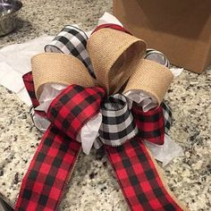 a red and black plaid bow sitting on top of a counter next to a box