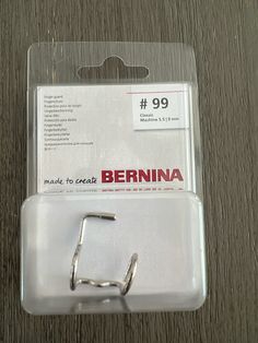 a pair of metal clips sitting on top of a wooden table next to a package