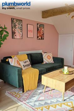 a living room with pink walls and green couches in front of a coffee table