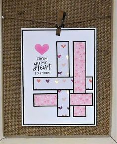 a white frame holding a card with pink hearts on it and a heart hanging from the front