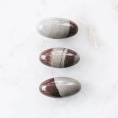 three stones sitting on top of a white surface