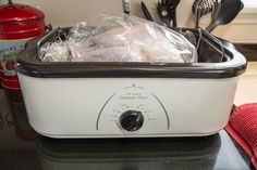 an image of a crock pot on the counter with some food in it and utensils