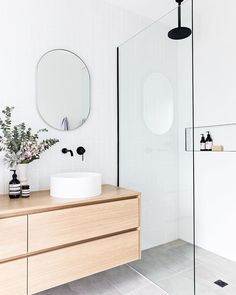 a bathroom with a sink, mirror and shower stall in it's center area