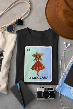 Embrace your heritage with our 'La Mexicana Loteria Shirt'! This vibrant tee celebrates Mexican pride and Latina beauty with its stunning Loteria card design. It's the perfect gift for any proud Latina, combining tradition and style flawlessly. Made with love and care, this Mexican pride shirt is sure to become a favorite in your wardrobe. To order, simply click the button and follow the easy steps. And to keep your shirt looking great, wash it with like colors and tumble dry on low. Elevate you Mexican Outfits, Loteria Shirts, Mexican Pride, Mexico Shirts, Mexican Gifts, Shirt Quotes, Mexican Outfit, Latina Fashion, Adidas Outfit